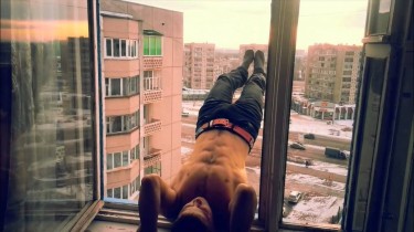 Russian Man Hangs Off Building in Workout