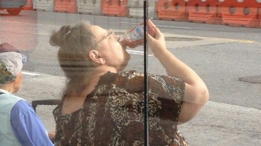 Woman in a Muumuu Drinking a Bottle of Ketchup